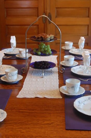 The table is set with fine china and blue placemats