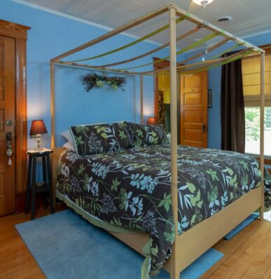 A room painted blue with a modern floral bedsheet a top the bed